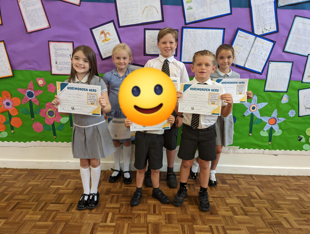 Photo showing winners of the Horsmonden Hero award holding up their certificates and smiling for the camera.