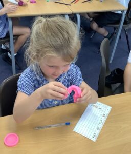 Children in Year 2 are seen experimenting with different materials to see which ones can change shape and why.