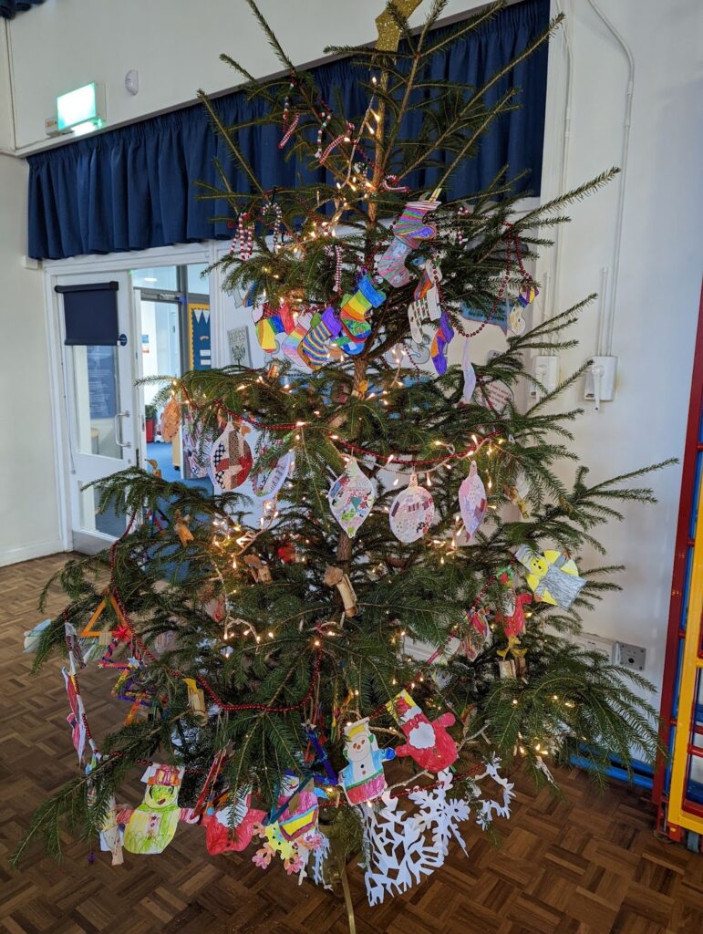 A photo of a Christmas Tree that has been decorated by Horsmonden pupils in the main hall area of the academy building.