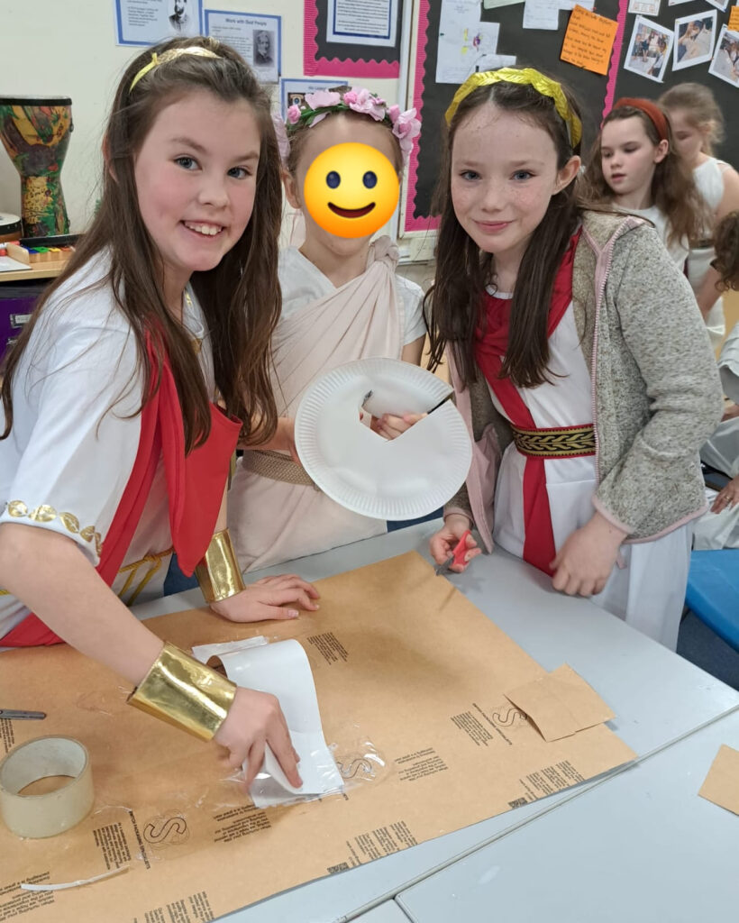 Students smiling for a photo dressed as Romans
