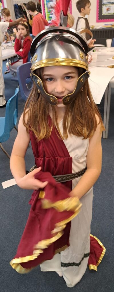 A student smiling for a photo dressed as a Roman