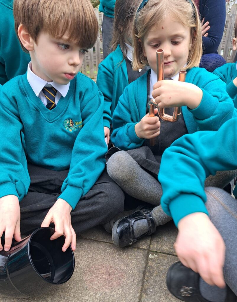 Two students pictured looking at a piece of copper pipe together.
