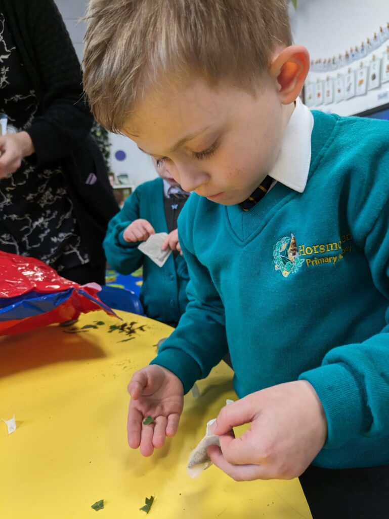 A student is pictured concentrating at his desk, as he creates his own teabag, using different materials.