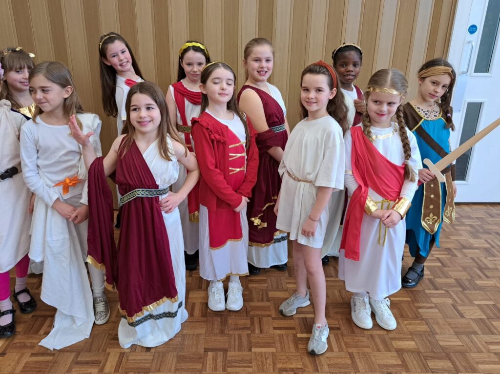 Students smiling for a photo dressed as Romans