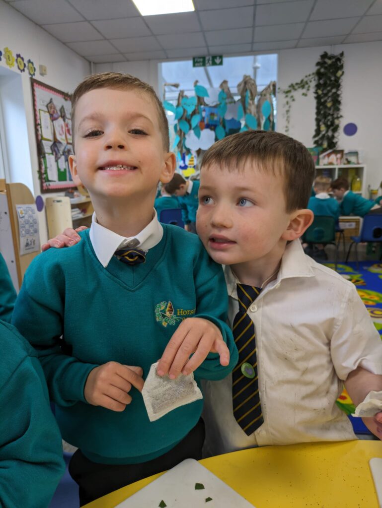 A student smiling for a photo with their work