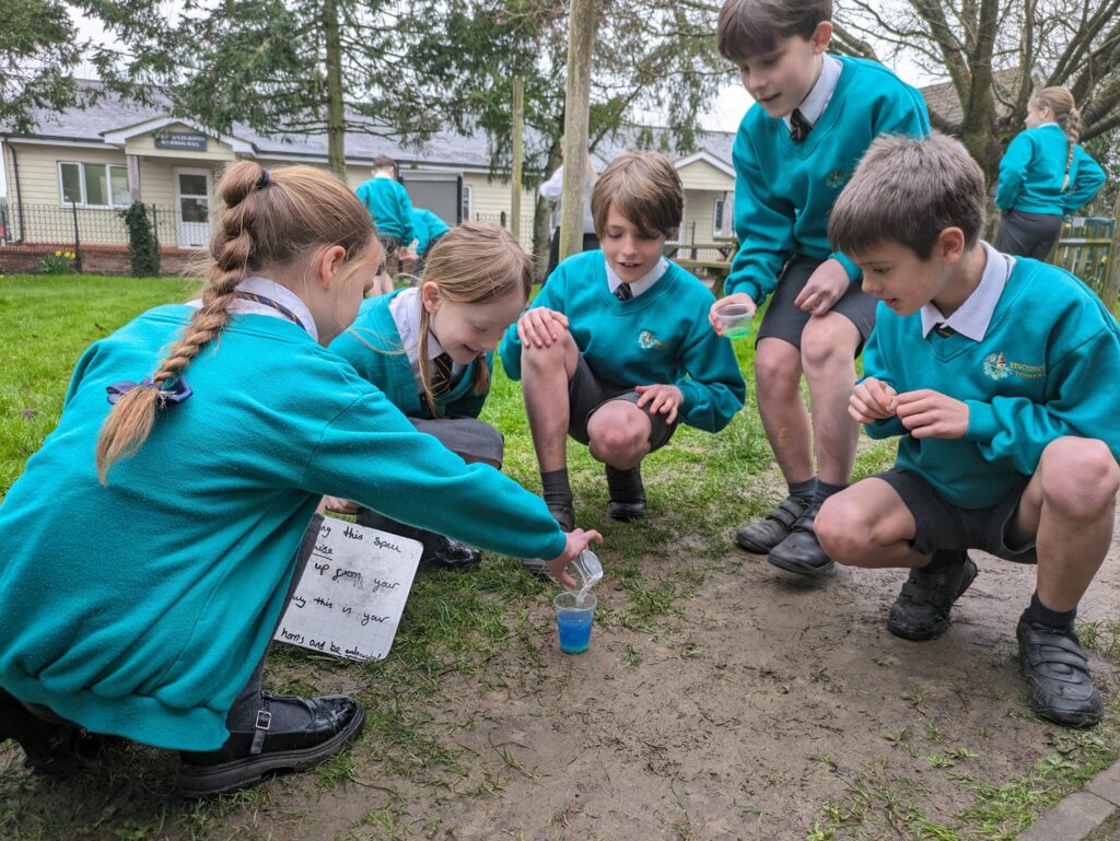 Students crouched outside watching their 'potion'