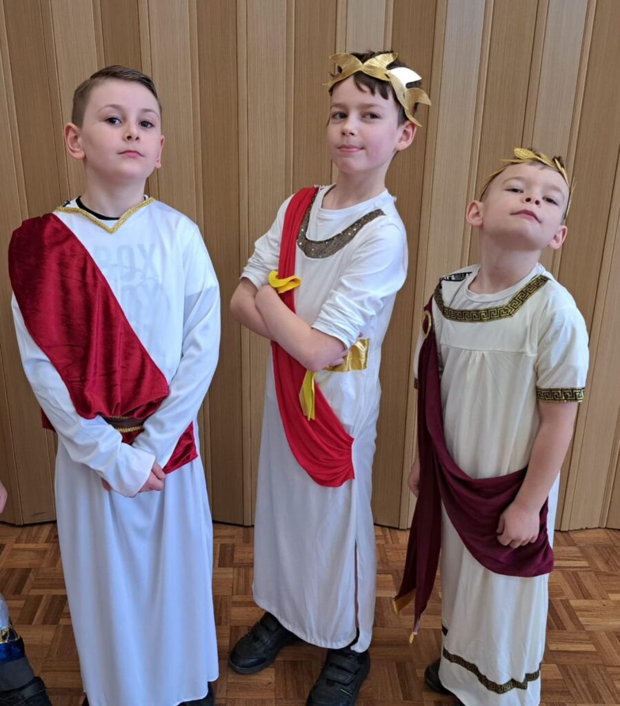 Students smiling for a photo dressed as Romans