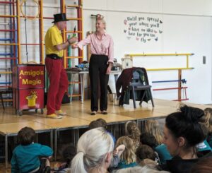 Photo taken of the Magic Show, organised by FoHPS, with a female member of staff seen participating in a trick with the magician.