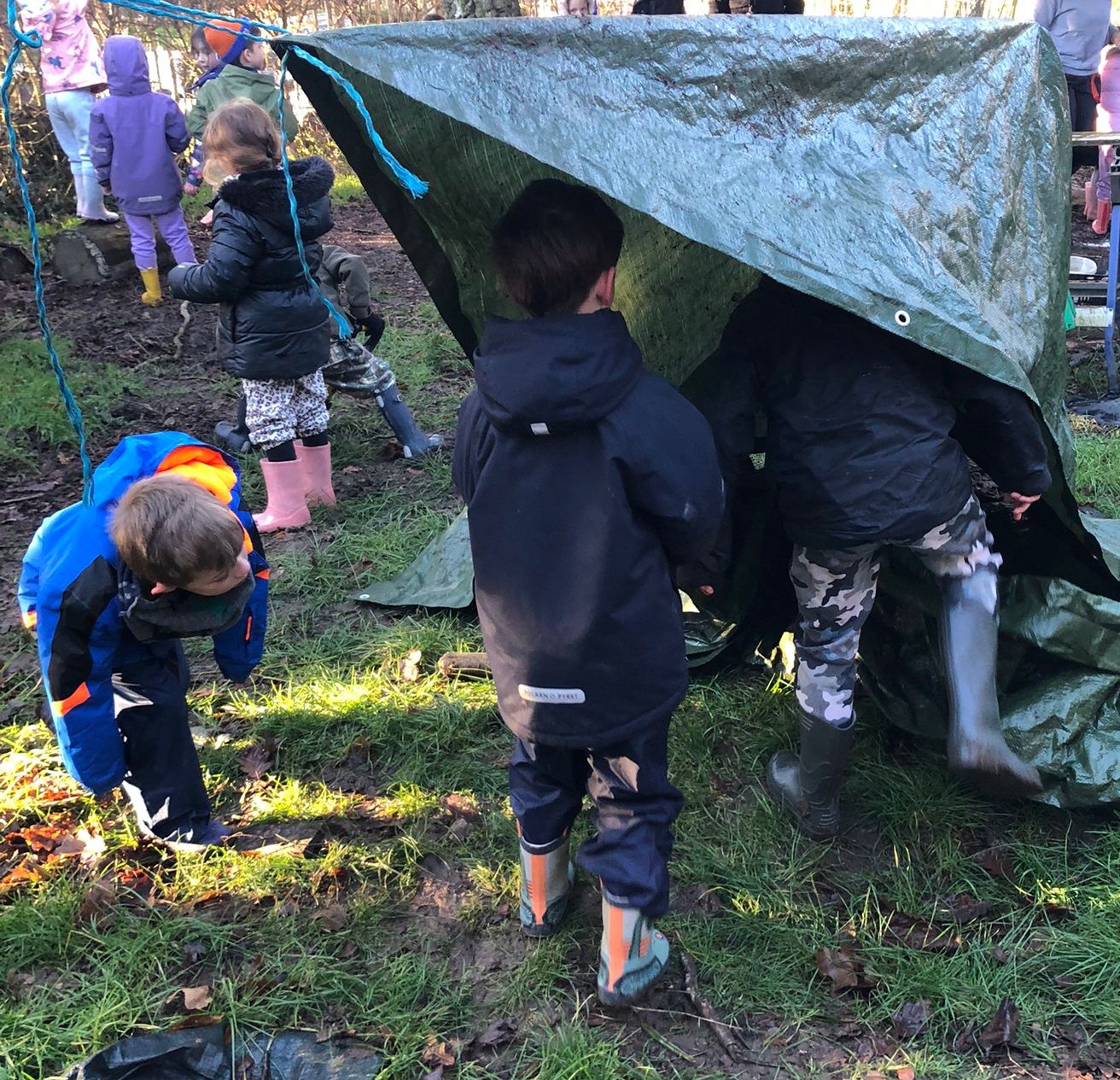 Several students under a tarpaulin