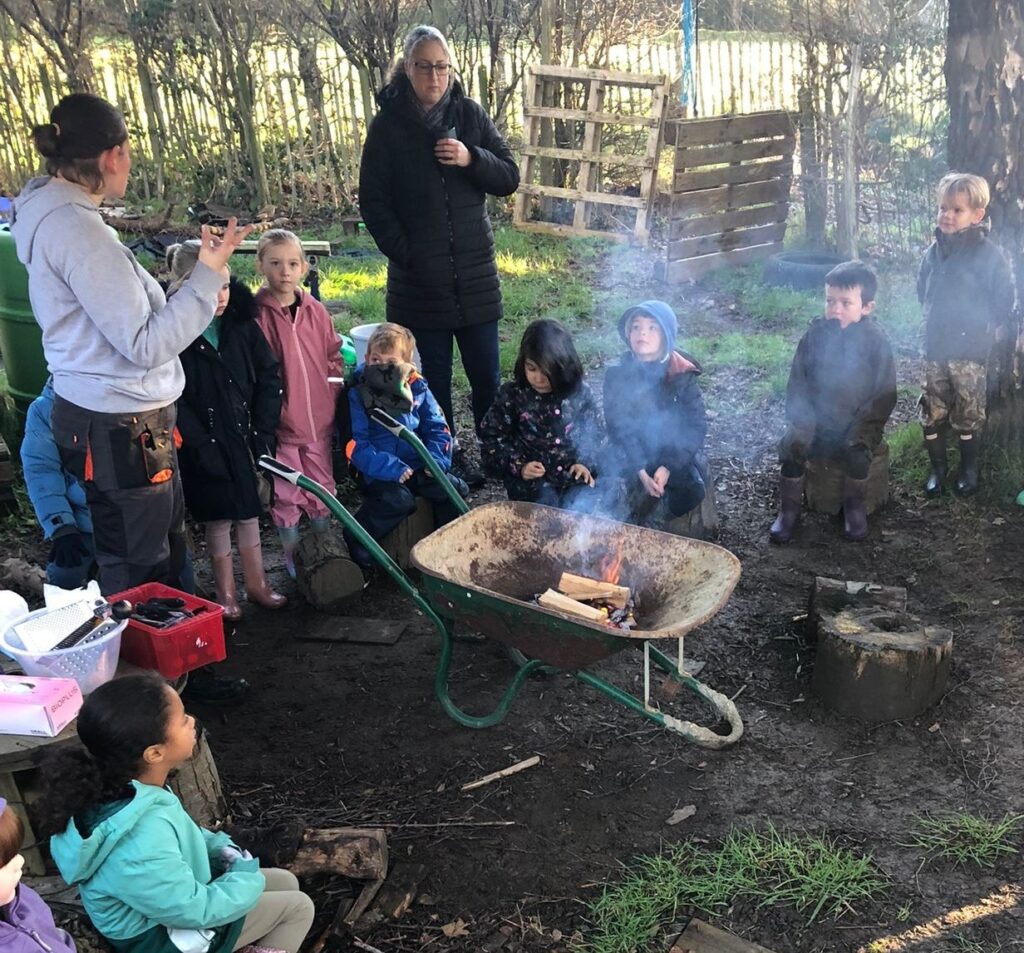 Students stood around a wheelbarrow containing a small fire