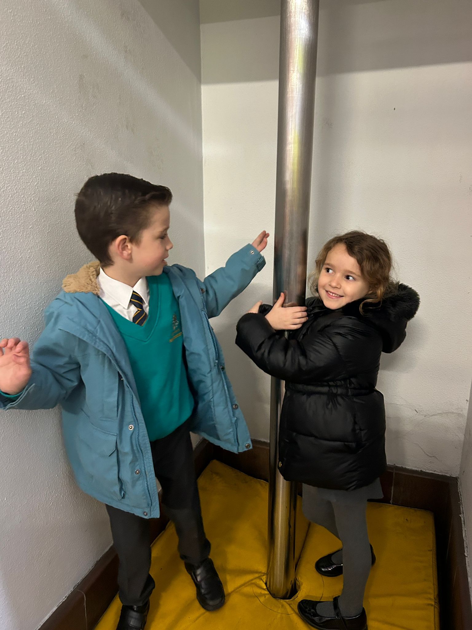 2 students stood with a fireman's pole